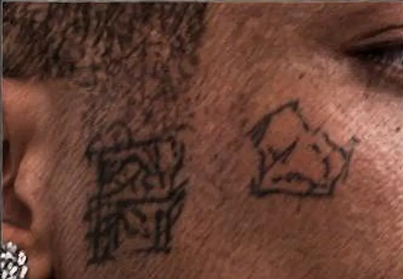 Close-up of the crown and glyph tattoos on KUBE's cheek