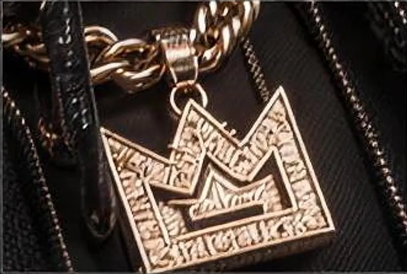 The gold crown pendant on a heavy gold chain